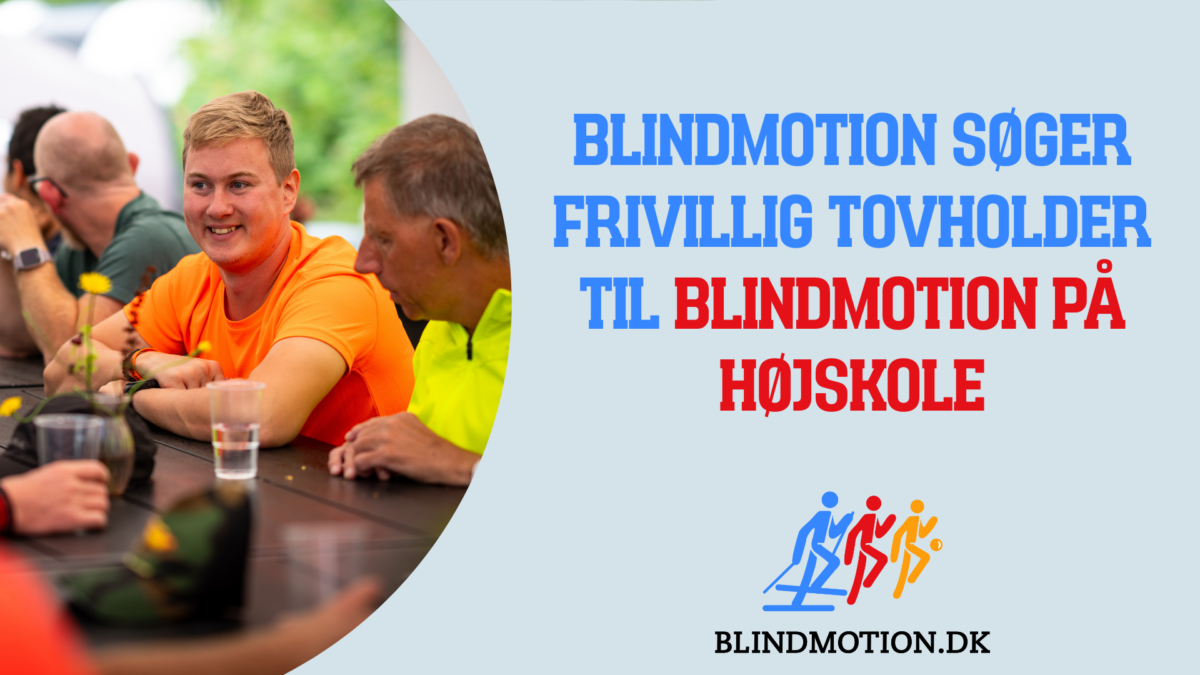 En mand sidder ved et bord og smiler